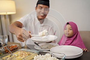 Man breaking the fast dinner with his daugther and family