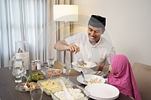 Man breaking the fast dinner with his daugther and family