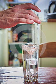 Man breaking the ice, cooling water in a glass