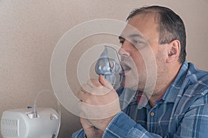 Man breathes through a nebulizer mask. therapeutic procedures, carrying out inhalations. treatment of respiratory diseases and