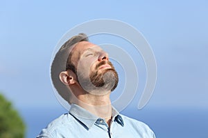 Man breathing deep fresh air outdoors