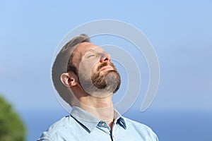 Man breathing deep fresh air outdoors photo