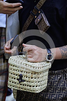 Man with Breitling watch and wicker bag with Fendi trousers before Fendi fashion show, Milan Fashion