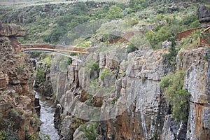 Man on bridge over river gorge