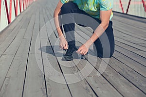 The man on the bridge ties his sneaker before jogging