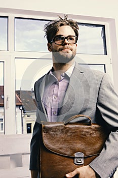 Man with briefcase on glass door background. Education and work concept. Serious man or professor