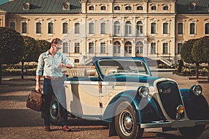 Man with briefcase near classic convertible