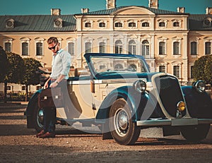 Man with briefcase near classic convertible