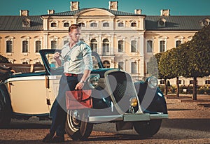 Man with briefcase near classic convertible