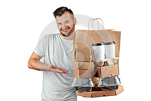 Man in a bright T-shirt giving a fast food order isolated on a white background. Male courier worker is holding food. Home