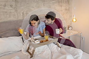 Man bringing breakfast on a tray to woman