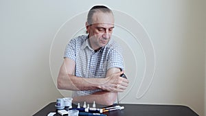 A man brings to the hand the reading device to the sensor for measuring glucose