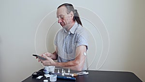 A man brings to the hand the smartphone for measuring glucose in the blood