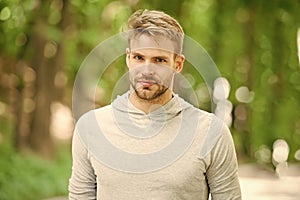 Man with bristle on calm face, nature background, defocused. Skin care concept. Man with beard or unshaven guy looks