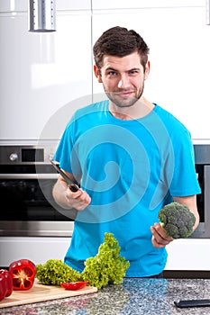 Man with broccoli and knife in hands