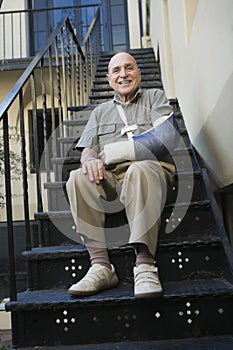 Man With Broken Arm Sitting On Stairs