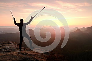 Man with broken leg and medicine pole above head stay on peak.