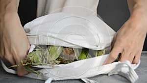 Man brought in white fabric cotton tote bag and put fresh ripe ear corn on stone table top