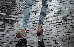 Man brown hipster shoes and legs in the street with black bricks taking a step