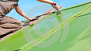 Man Brushing Green Paint onto the Roof