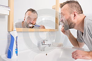 Man brushing his teeth in bathroom