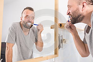 Man brushing his teeth in bathroom