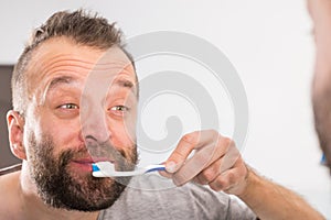 Man brushing his teeth in bathroom