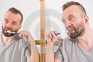 Man brushing his teeth in bathroom