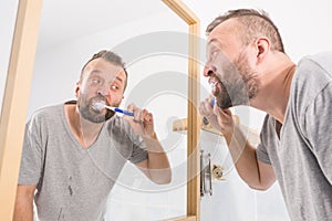 Man brushing his teeth in bathroom