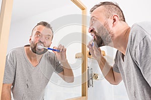 Man brushing his teeth in bathroom