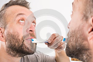 Man brushing his teeth in bathroom