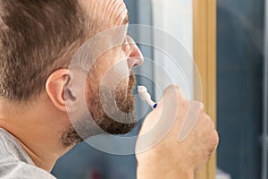 Man brushing his teeth in bathroom