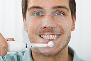 Man Brushing Teeth With Electric Toothbrush