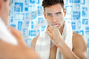 Man brushing teeth in front of mirror