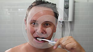 Man Brushing Teeth at Home in Bathroom