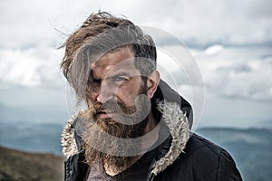 Man with brutal bearded appearance, brutal unshaven man looks untidy. Man with long beard and mustache wears jacket