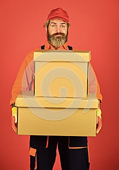 Man builder in boilersuit hold boxes. moving to new apartment. happy man cardboard box. carrying boxes inside the