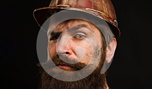 Man builder. Closeup portrait serious construction worker in building hard hat. Bearded workman in protective helmet