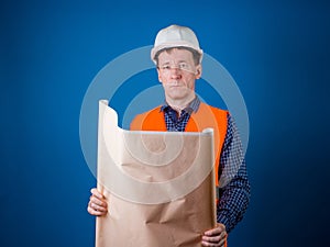 The man is a builder. A guy in a construction helmet with drawings