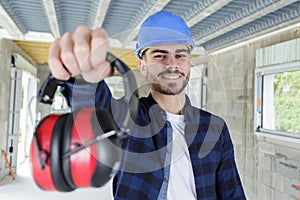 man builder holding ear protection