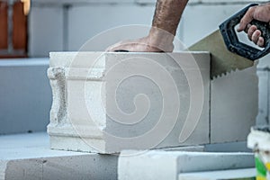 Man builder sawing a gas-silicate brick