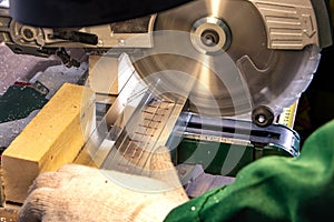 A man builder saws a board with a circular saw in the workshop