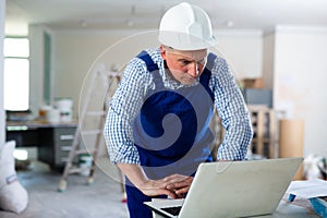 Man builder using laptop in construction site