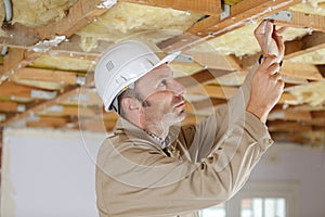 man builder using screwdriver on ceiling