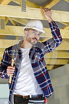 Man builder on wooden frame house
