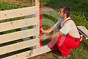 Man building wooden fence