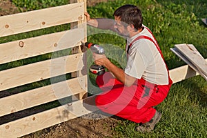 Man building a wooden fence