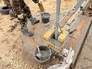 Man builds a brick wall at a construction site