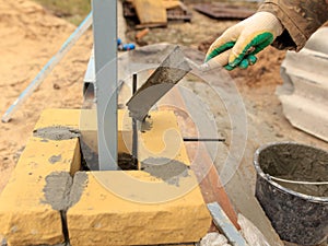 Man builds a brick wall at a construction site