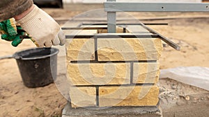 Man builds a brick wall at a construction site